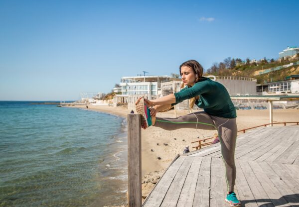 How to run for a marathon - Woman do streching by the sea