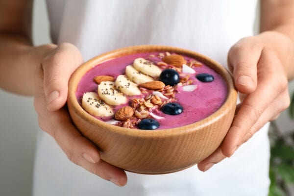 finish a marathon Woman standing with a helthy meal bowl