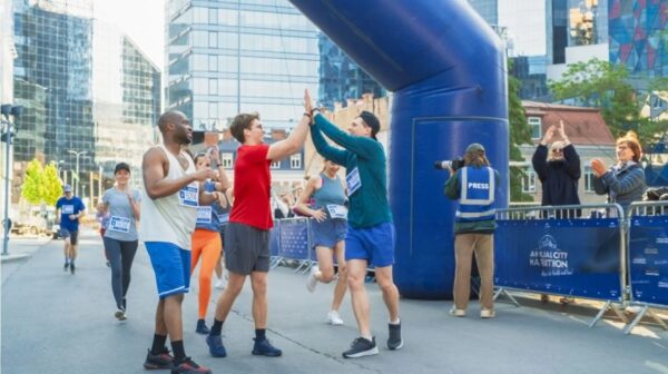 finish a marathon - small group of runners cheering after marathon finis line