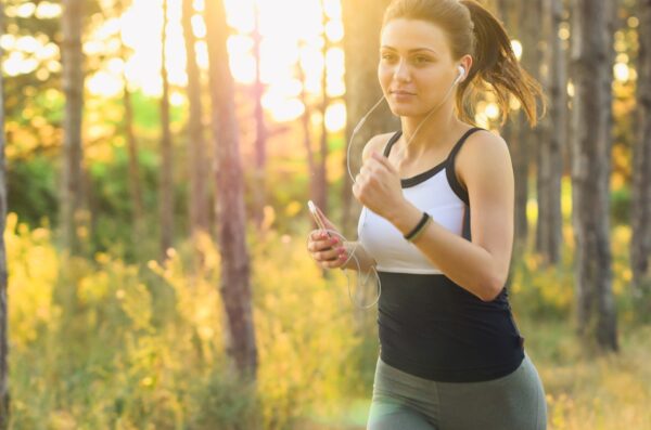 finish a marathon - woman training in nature with earbuds