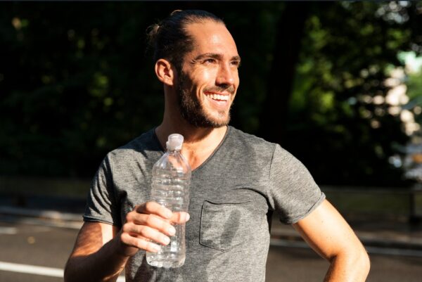 fluid balance - man drinking from a bottle after a sweating training session