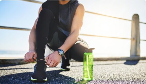 fluid balance runner getting ready for run with bottle of fluid