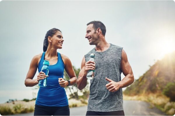 a runners diet - couple drinking water on break to hydrate on a running trip