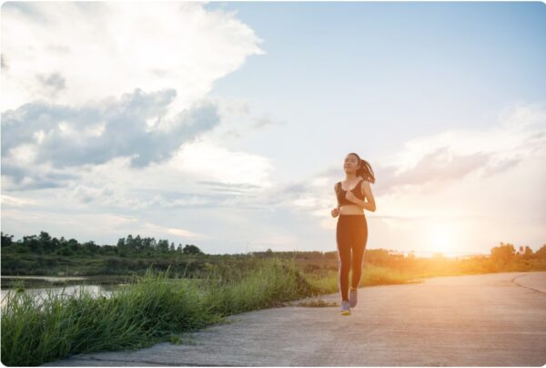 Marathon Training Schedule - Happy woman runs LSD in the park.