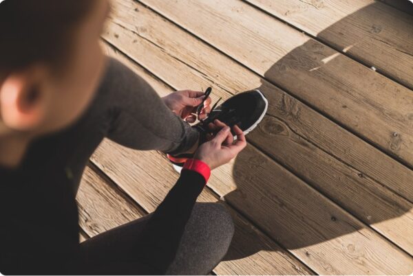 Marathon Training Schedule - Woman preparing her sneakers before starting to run