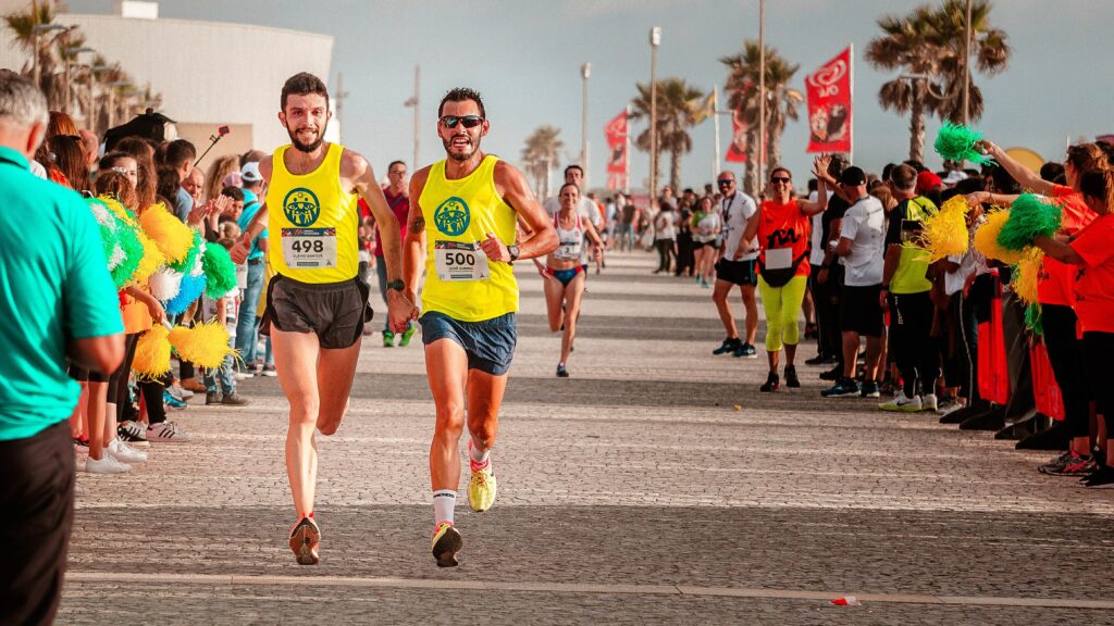 7-best-ways-preparing-a-marathon-race-and-complete-two-marathon-friends-hold-each-other's-hand-just-before-finish-line