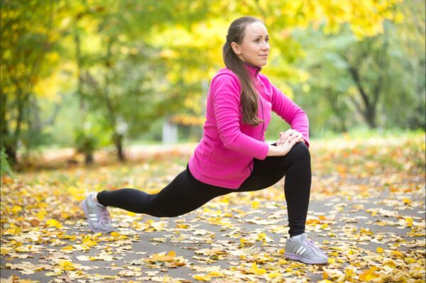 Recover post marathon - Autumn stretching outdoors high lunge exercises