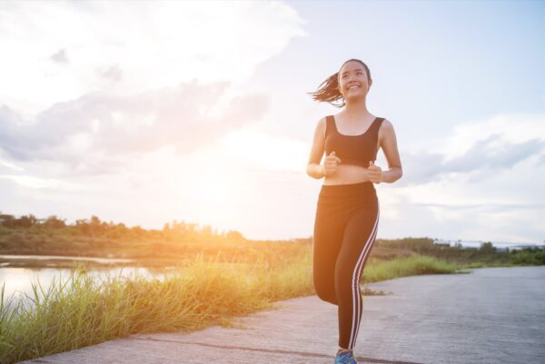 Recover post marathon - Runner smiling mid-stride during a sunset jog
