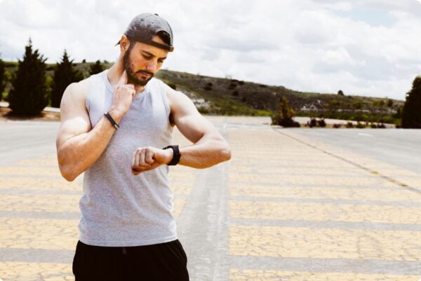 marathon training for outstanding results - A runner checking his heart rate before intervals