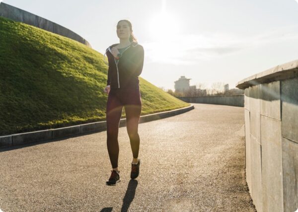 marathon training plan - young woman running on a road