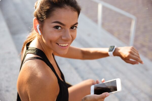 marathon training progress -female runner sitting and checking her running data on a sportswatch