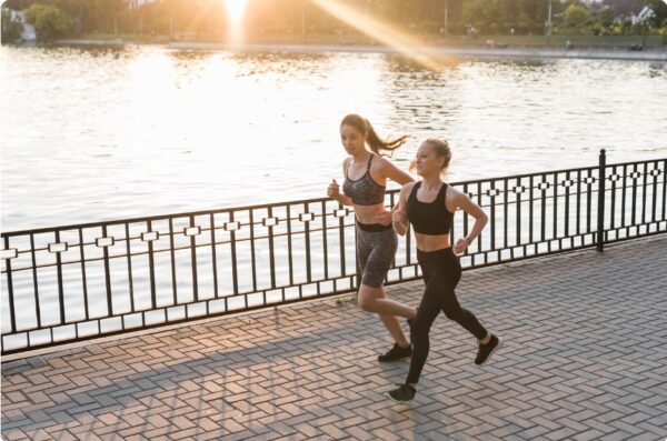 running for beginners - Two friends jogging slowly while chatting.