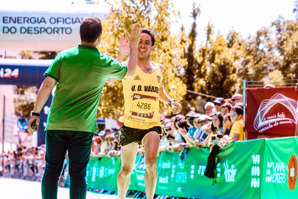 Marathon-training-for-beginners-running-man-doing-high-five-to-standing-friend