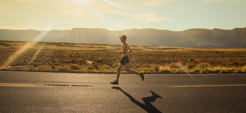 Marathon-training-for-beginners-man-running-on-road-in-open-landscape