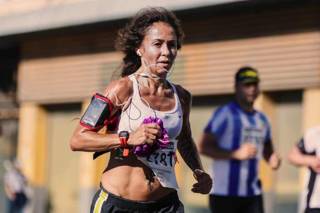 Best-Music-to-Running-mature-woman-in-race-listening-to-music-with-earplugs