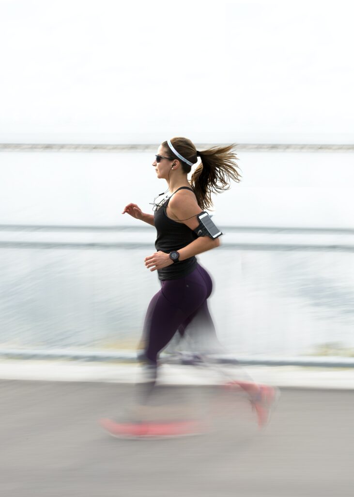 Best-Music-to-Running-strong-woman-running-with-earplugs
