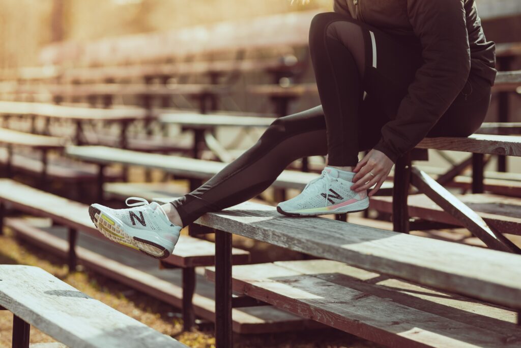 How-to-Train-For a-Marathon - 10-Tips-From-Top-Runners- Woman-sitting-and-check-her-running-shoe