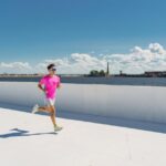 proper running form - man running along a beachside