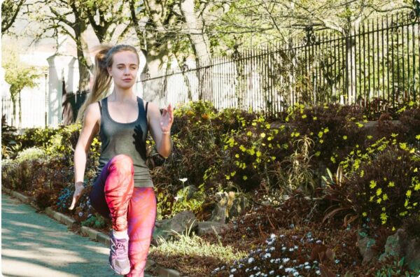 proper running form woman making high knee lifts before running