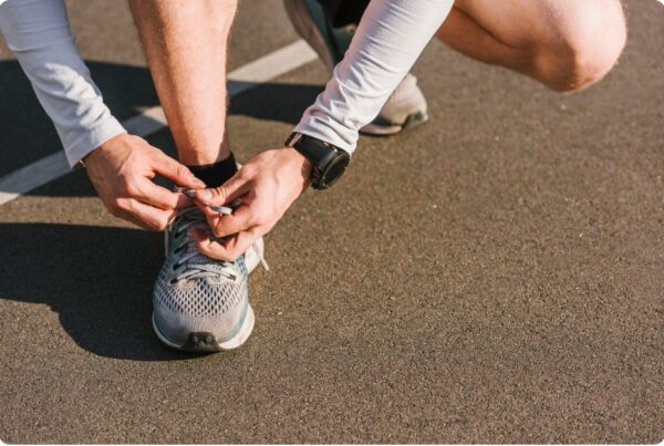 training zones - Close-up of man tying his shoe laces with a smart wristwatch ready to using the personal HRM training zones