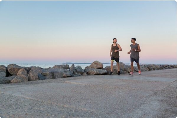 Two runners training together on a path, building endurance through steady pacing.