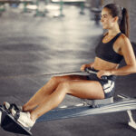Cross training for runners - female athlete in a rowing machine