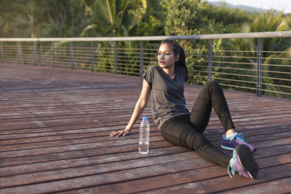 Runner pausing to hydrate at sunrise, showing calm reflection