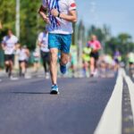 The Best Half Marathon Tips For Beginners Runner competing in a marathon race on a city road.