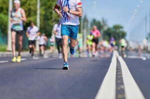 Runner competing in a marathon race on a city road.